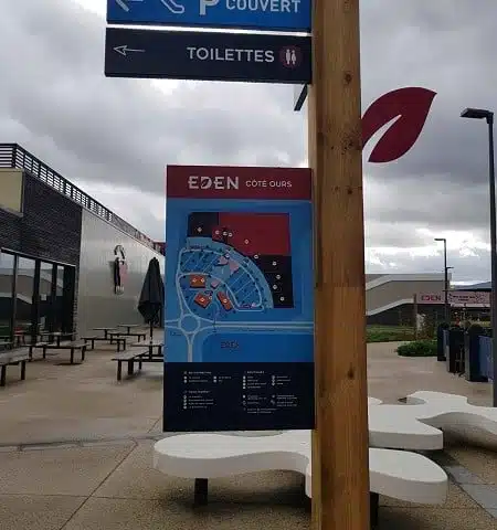 Mât bois signalétique directionnelle sur plot béton center commercial Eden Ours Servon- Semios