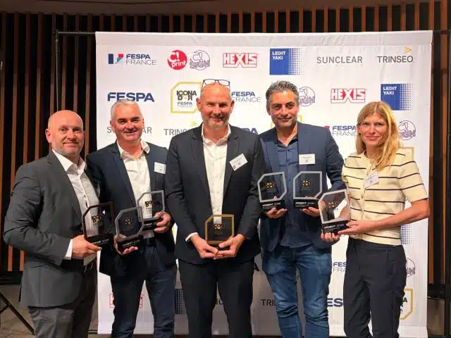 Photo regroupant 5 personnes présentes à la cérémonie des Icona d'Or de Lyon le 24 septembre 2026. Ils tiennent dans leurs mains 7 trophées au total, représentant les 7 récompenses attribuées au groupe Oxysign.