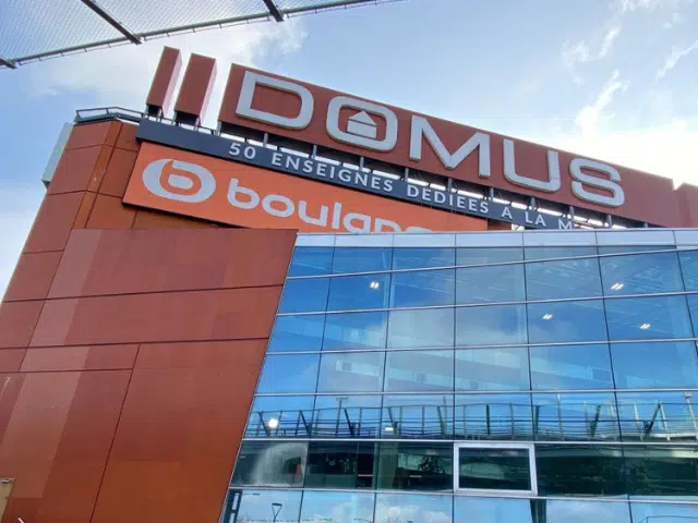 Vue sur les enseignes XXL du centre commercial DOMUS indiquant plus de 50 enseignes à l'intérieur.